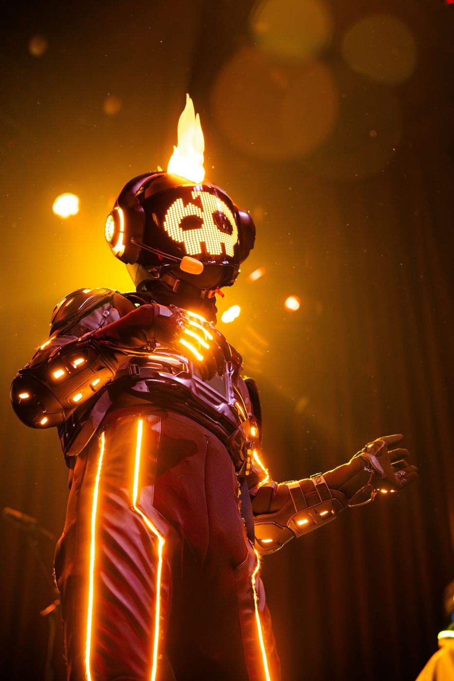Performer in a light-up, flame-effect skull costume on stage