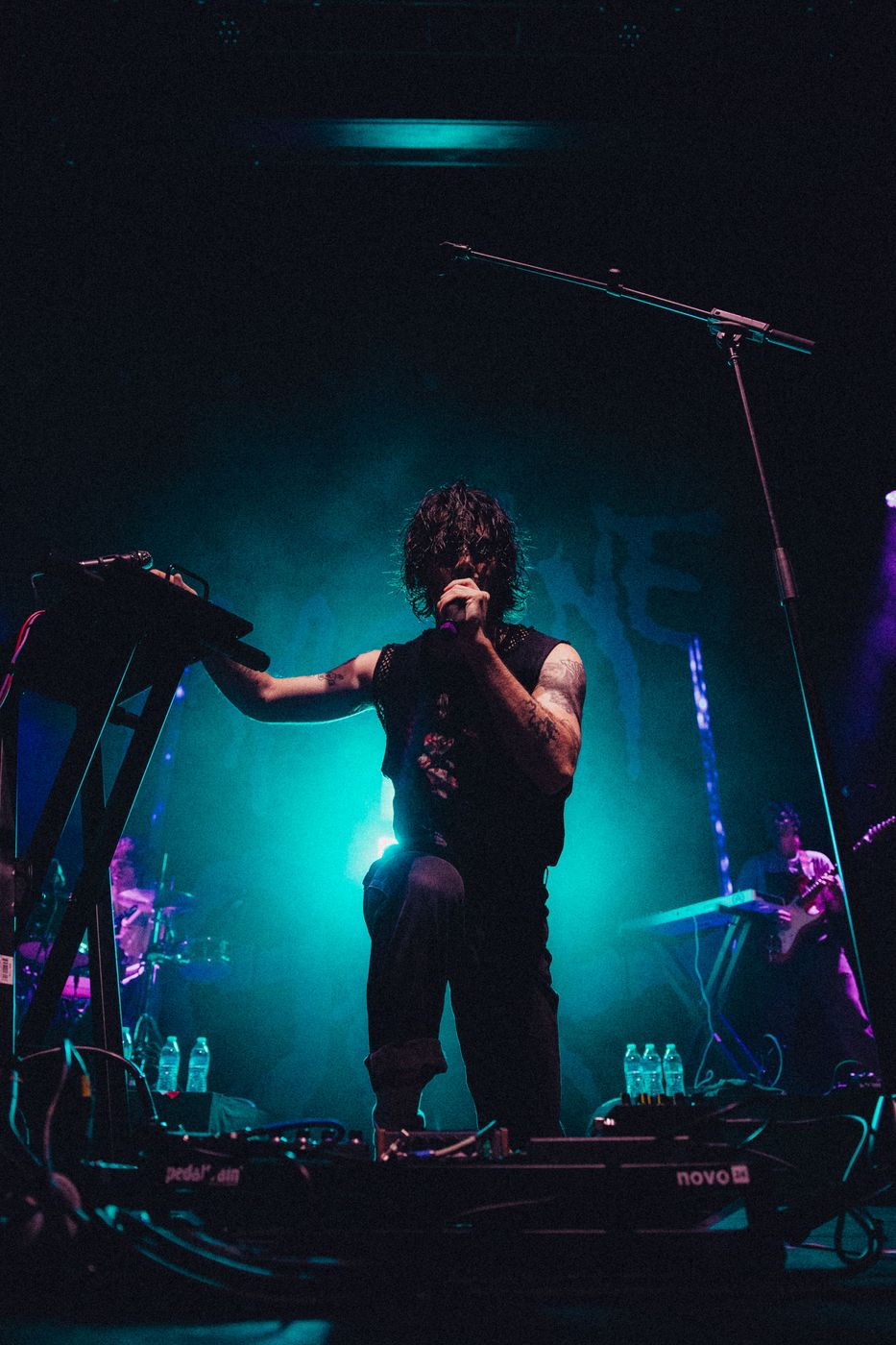 Performer captured mid high-kick on stage in front of a red curtain