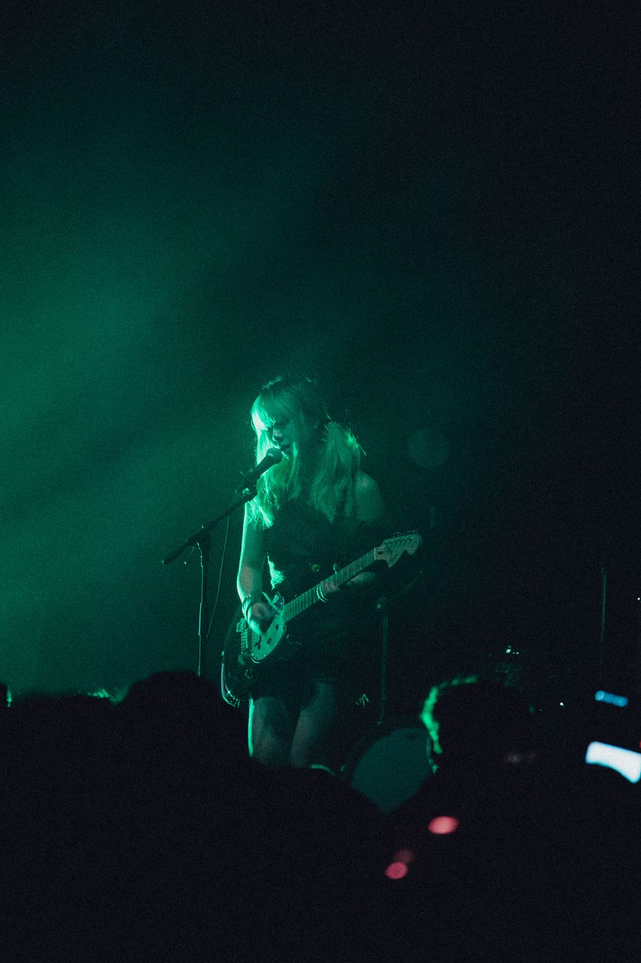Black and white silhouette of a guitarist backlit by a glowing circle of light