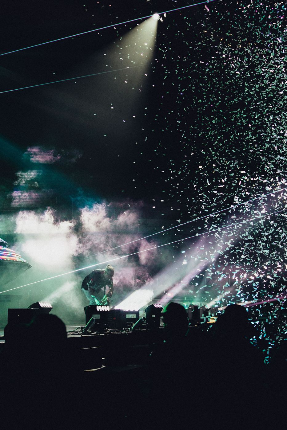 Saxophonist performing through confetti and stage smoke
